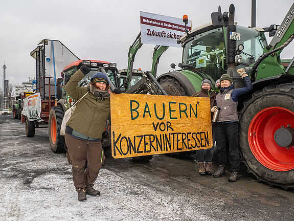 Bäuerinnen vor Traktor mit Transparent
