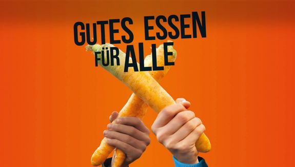 Zwei gekreuzte Möhren, darüber der Spruch "Gutes Essen für Alle"